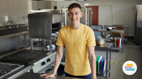 Young white man in a large catering kitchen