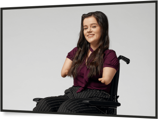 Girl in wheelchair smiling at camera
