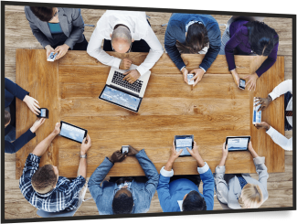 People on devices sitting round a table